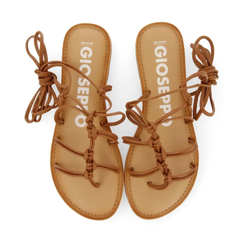 Mambai women's flat tan leather sandals with thin straps and decorative knots